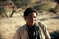 Rencontre dans le désert du Kalahari avec un représentant du peuple des cueilleurs-chasseurs. Le Bushman se définit comme "homme par excellence" et parle une langue Khoisan, où les consonnes sont produites par un claquement de langue. Le Bushman est un nomade qui vit depuis toujours dans le désert. Il chasse les animaux sauvages, avec arc et flèches, se soigne avec les plantes, habite une hutte constituée de branches et de feuillages. Le développement de la propriété privée en Namibie a freiné le nomadisme et contraint nombre de Bushmen à une vie sédentaire... bushman,kalahari,namibie,botswana,afrique. 