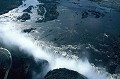 Survol en hélicoptère des chutes Victoria découvertes en 1855 par l'explorateur anglais David Livingstone. Ce site est appelé par les tribus africaines locales "la fumée qui tonne". En amont des chutes, à proximité de la faille, vivent des hippopotames et il n'est pas rare d'observer des éléphants nageant d'un îlot à l'autre... zambeze,chutes,victoria,zimbabwe,zambie. 