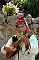 Sur cette vue, le musicien utilise un instrument à vent, la flûte de pan et une petite guitare à cordes pincées, le charango, qui épouse la carapace du Tatou, animal en voie de disparition, aujourd'hui protégé. Titicaca,taquile,perou. 
