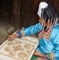 Certaines minorités chinoises (Miao, Gejia...) maitrisent parfaitement la technique du batik, un tissu imprimé en bleu indigo et parfois en 4 ou 5 couleurs. Le processus : d'abord un dessin sur un tissu blanc pouvant représenter des formes géométriques, des fleurs, des oiseaux, des poissons..., ensuite application de cire fondue sur le tissu avant de tremper celui-ci dans du colorant indigo, l'étape finale consistant à enlever la cire du tissu en la faisant bouillir dans l'eau. La cire étant assez cassante peut avoir de fines fissures, par lesquelles le colorant entre... batik,minorites,chinoises,guizhou,chine. 
